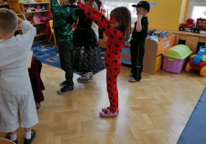 Dzieci w przebranach tańczą układ taneczny.
